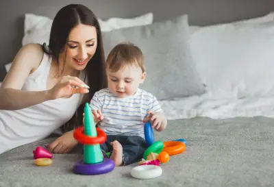 young mother playing blocks with her baby